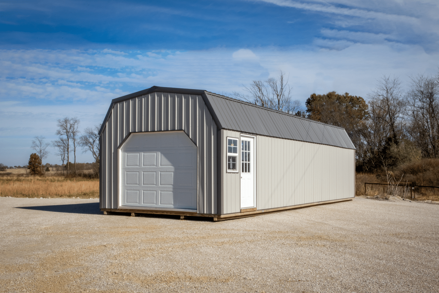 long beige garage with white garage door, entry door, and windows in ellsinore