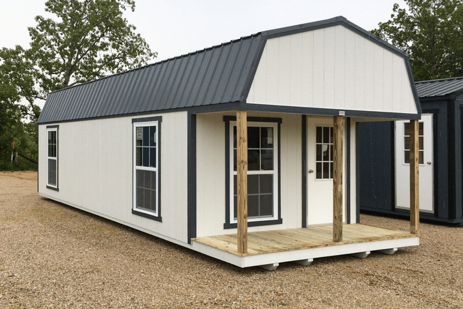 gray and white prefab cabin with porch and entry door and windows in ellsinore